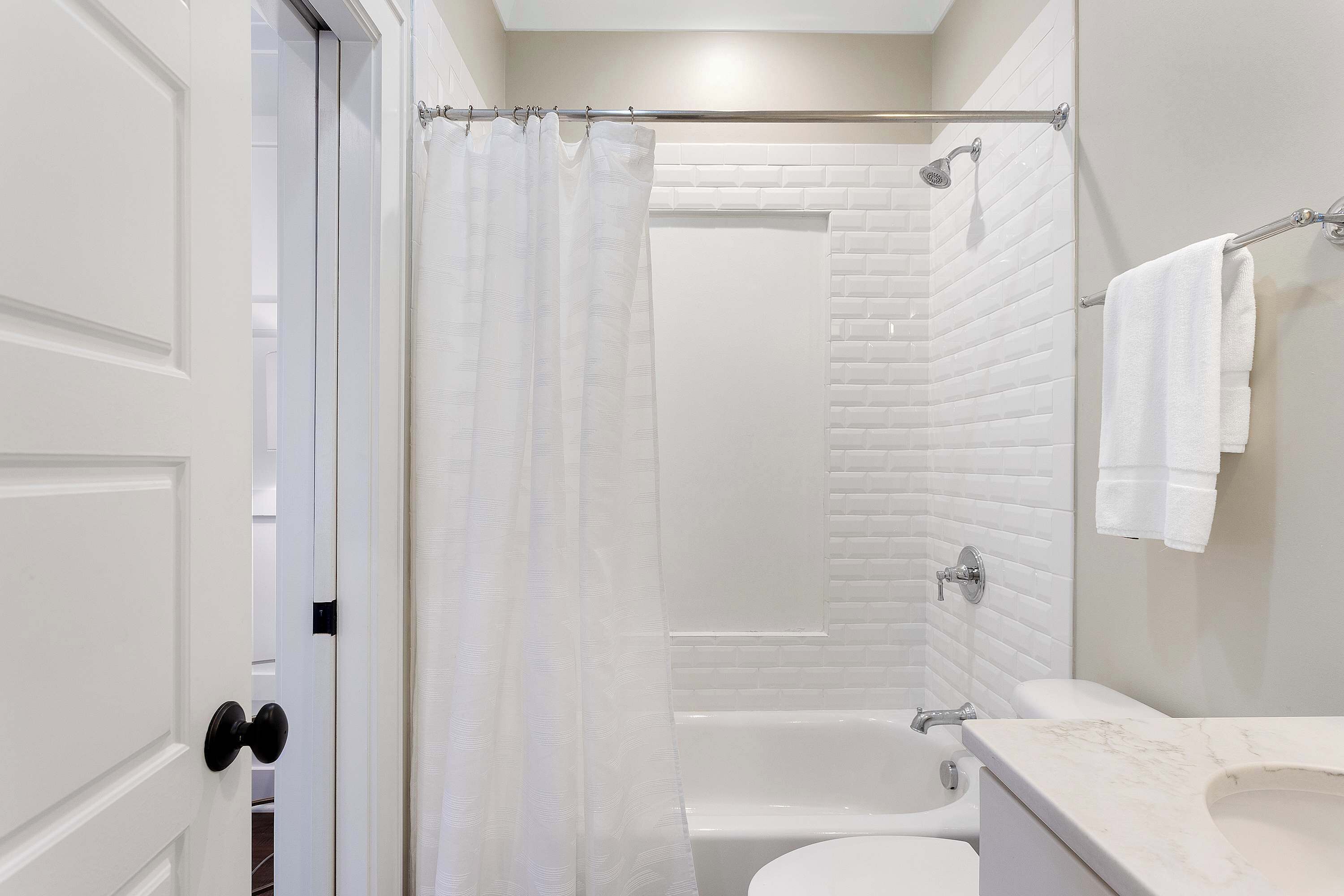 Un baño moderno con una bañera blanca, ducha y retrete.