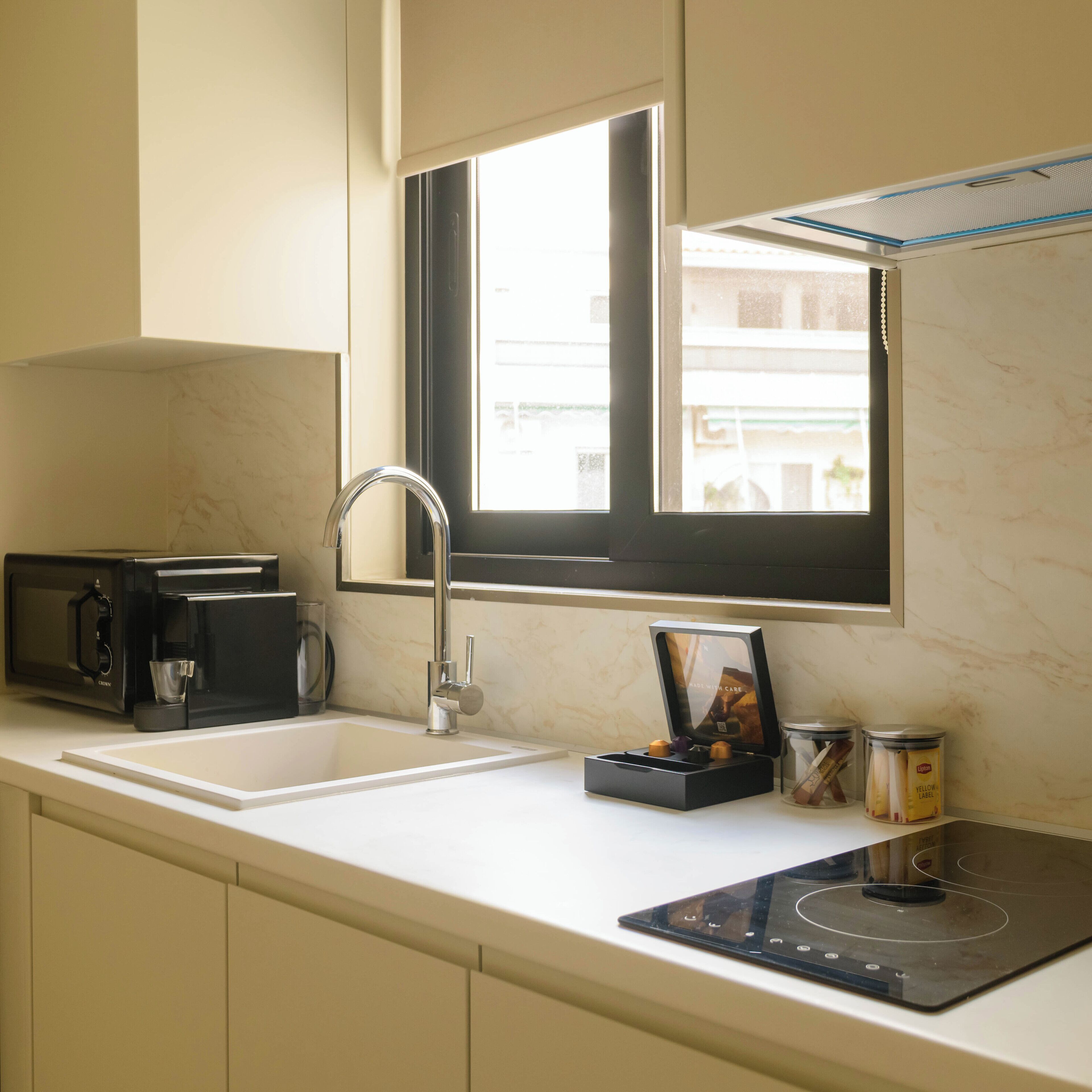 Eine moderne Küche mit Einbau-Mikrowelle, Spüle und einem Fenster über der Arbeitsplatte.