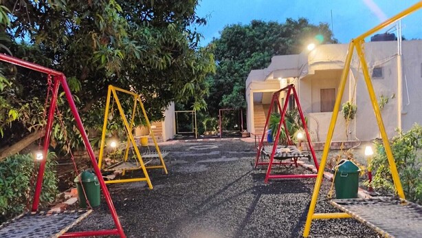 Ένα παιδότοπος με κούνιες και ένα πλακόστρωτο μονοπάτι.