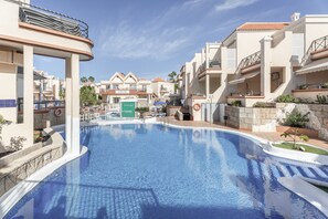Una piscina rodeada de edificios con balcones y un letrero que dice 'YOGA PARK'.