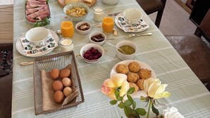 A breakfast table set with croissants, ham, eggs, and various fruits and beverages. - Nature immersion just 3 minutes from Tours (Mettray)