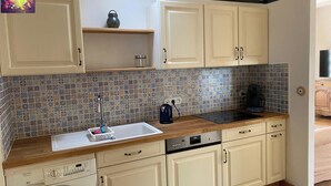 A compact kitchen with a washing machine, a coffee maker, and a dishwasher. - Nature immersion just 3 minutes from Tours (Mettray)