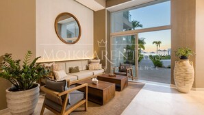 A modern living room with a sofa, coffee table, and potted plants. - Stylish Beachfront Studio by Moikkarentals (Puerto Vallarta)