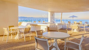 A rooftop bar with tables and chairs, overlooking a beach and the ocean. - Stylish Beachfront Studio by Moikkarentals (Puerto Vallarta)