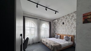 A bedroom with a bed, a chair, and a desk. - Heritage Old City Hotel (Baku)