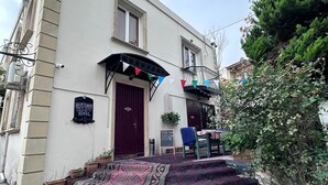 A building with a sign reading "Heritage Old City Hotel," a red door, and a patterned carpet leading to the entrance. - Heritage Old City Hotel (Baku)