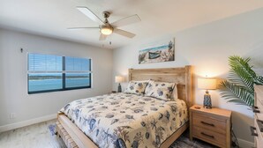 A bedroom with a bed, a ceiling fan, a window with a view, a nightstand, and a lamp. - Gulf View! 2B/2B CONDO AT ISLANDS END 804! Pool! (Fort Myers Beach)