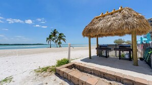 A beachside gazebo with a thatched roof, a concrete seating area, and a view of the ocean. - Gulf View! 2B/2B CONDO AT ISLANDS END 804! Pool! (Fort Myers Beach)