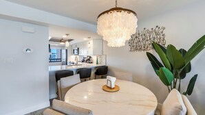 A dining area with a marble table, chairs, and a chandelier. - Gulf View! 2B/2B CONDO AT ISLANDS END 804! Pool! (Fort Myers Beach)