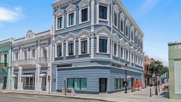 Un edifici d'angle d'estil arquitectònic clàssic, amb diverses finestres i un balcó.