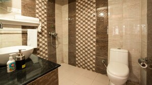 Une salle de bain avec un lavabo, des toilettes et une douche.
