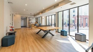 A spacious room with a large wooden table, black chairs, and a view through large windows. - Chic 2BR/2BA with Gym and Rooftop Access (Memphis)
