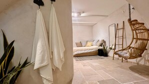 Ein Schlafzimmer mit einem Bett, einem Hängesessel und einer Leiter.