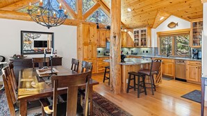 Un'ampia cucina con mobili in legno, un'isola centrale e un grande lampadario.