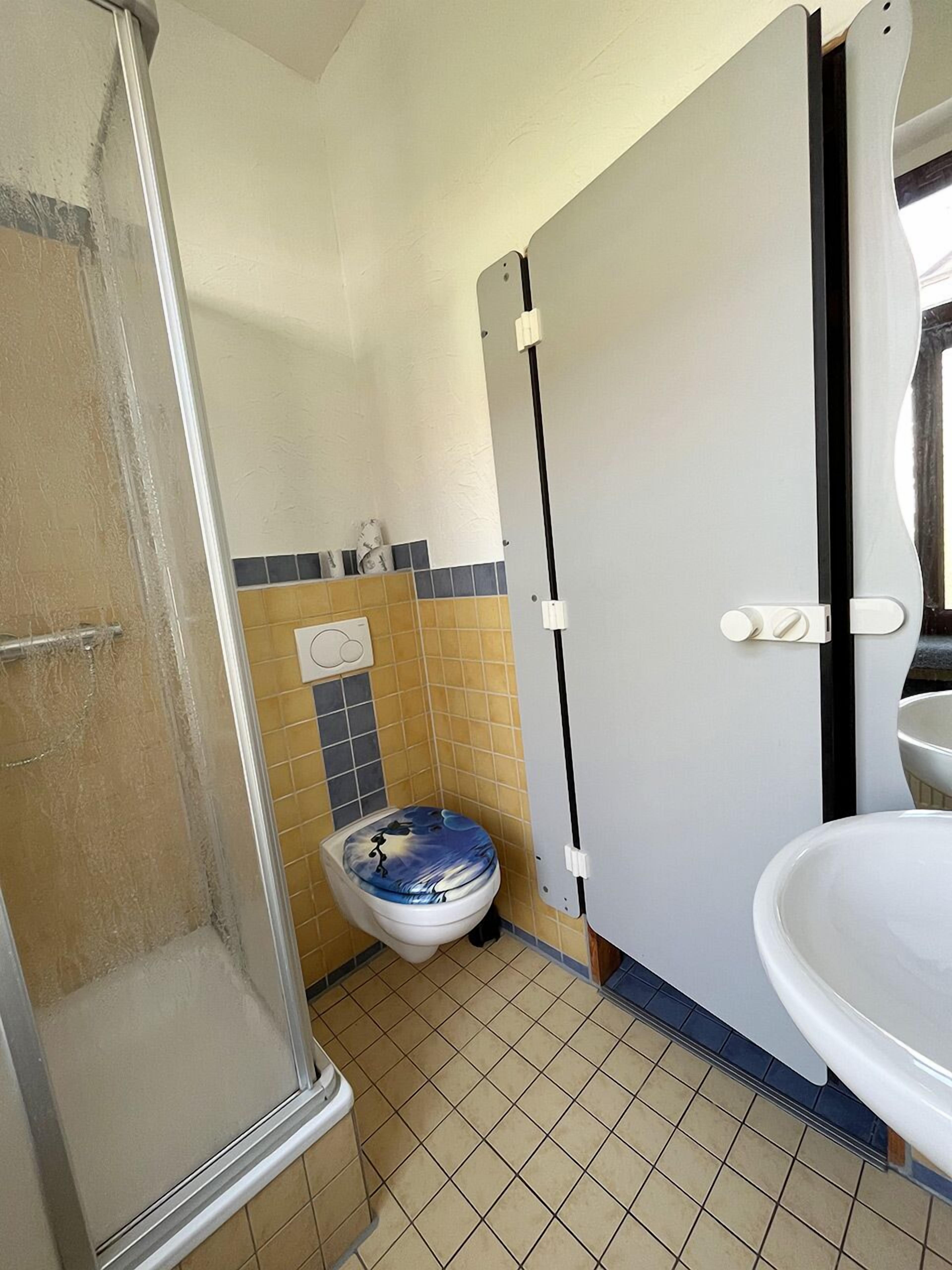 A bathroom with a shower, toilet, and sink.