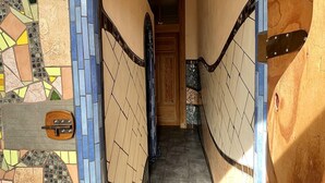 A hallway with a mosaic-tiled archway leading to a door. - Homeplanet Hostel (Leipzig)