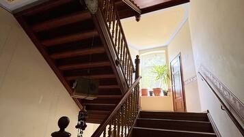 Una escalera de madera con techo decorativo y un reloj.