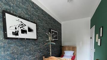 Una habitación con dos camas de madera, una mesa de madera y una silla.