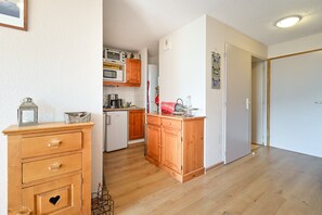 A kitchen with wooden cabinets, a microwave, and a coffee maker.