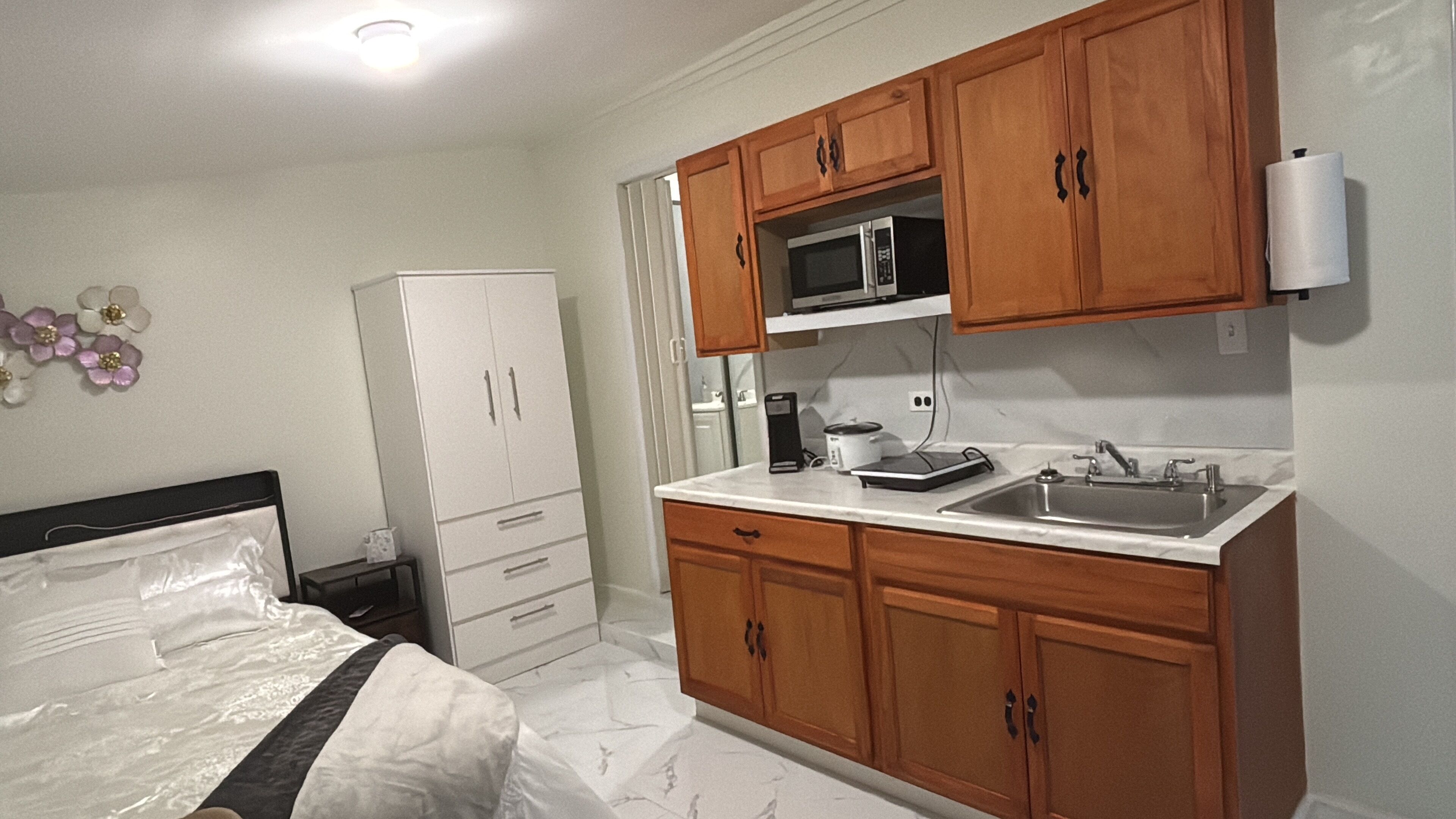 A compact kitchen with wooden cabinets, a microwave, and a sink.