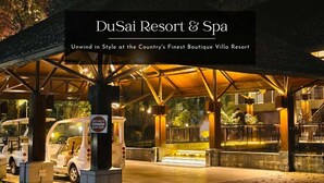 Ein gut beleuchteter Eingang zum DuSai Resort & Spa mit überdachter Wartezone und einem sichtbaren Verbotsschild.