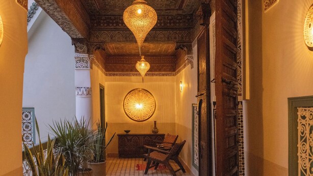 A corridor with patterned tiles, wooden doors, and hanging lamps. - Riad du Musée - Private boutique riad - 3 beds - jacuzzi (Marrakech)