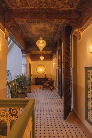 A corridor with patterned tiles, wooden doors, and hanging lamps. - Riad du Musée - Private boutique riad - 3 beds - jacuzzi (Marrakech)
