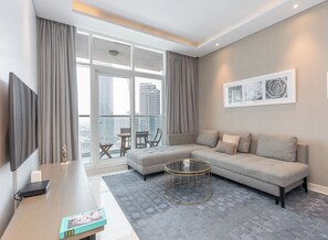 Een moderne woonkamer met een modulaire bank, een salontafel en een televisie.