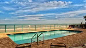Une piscine avec vue sur la plage et l’océan.