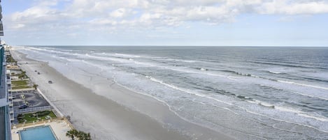 Une vue sur la plage, avec une piscine et un espace de stationnement.