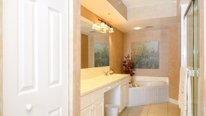A bathroom with a large mirror, a sink, a bathtub, and a shower. - Oceanfront Escape -  1007 Towers Grande (Daytona Beach Shores)