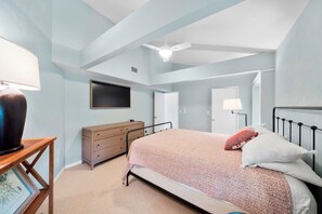 A bedroom with a bed, a dresser, a television, and a ceiling fan. - Ponce Inlet Waterfront Escape - 4 Bedroom 3 Bath (Ponce Inlet)