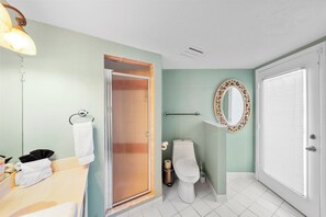 Un baño con inodoro, lavamanos, espejo y toallero.