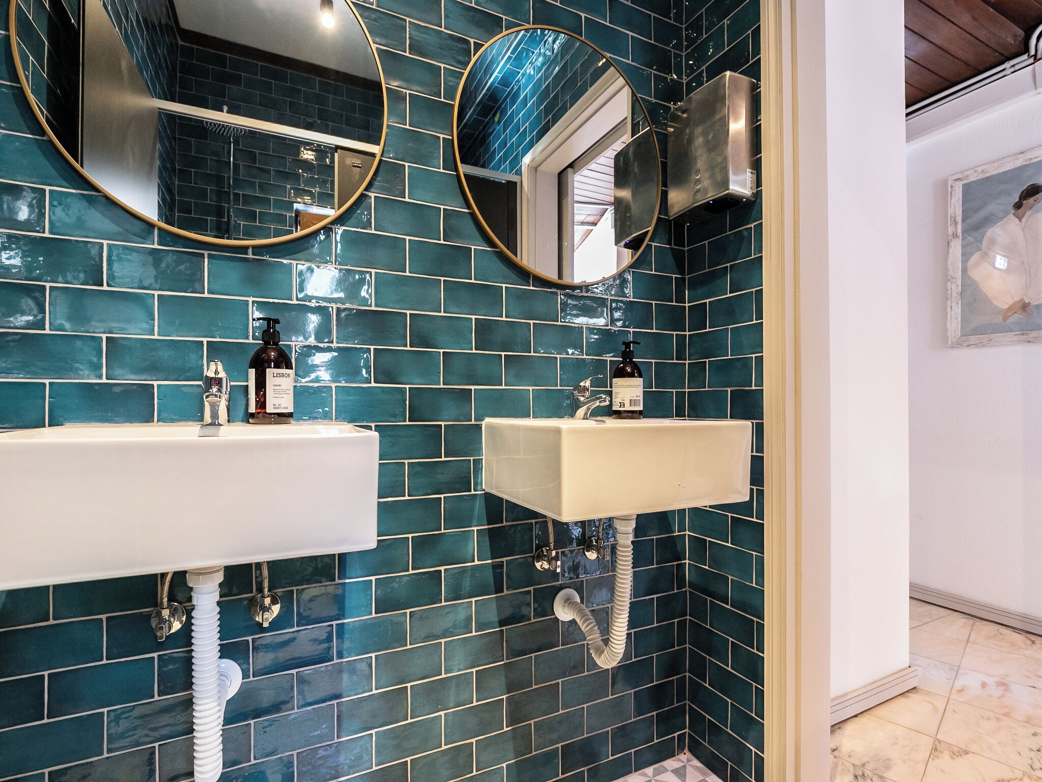 A bathroom with two sinks, a mirror, and a shower.