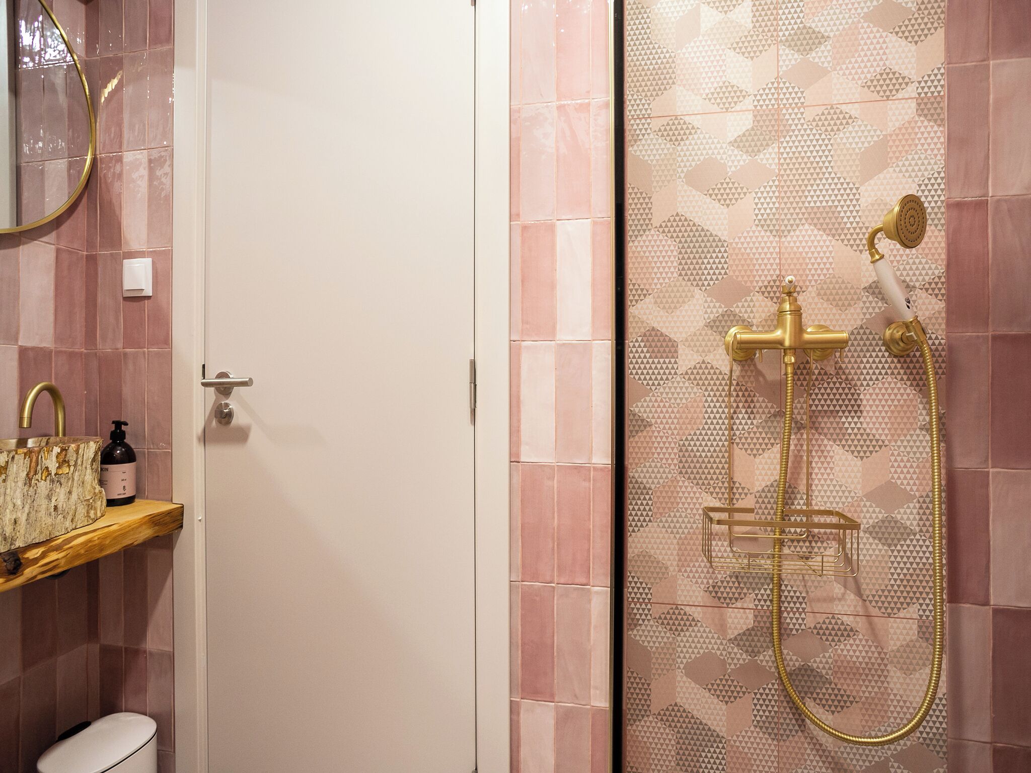 A bathroom with a shower, a sink with a mirror, and a toilet.