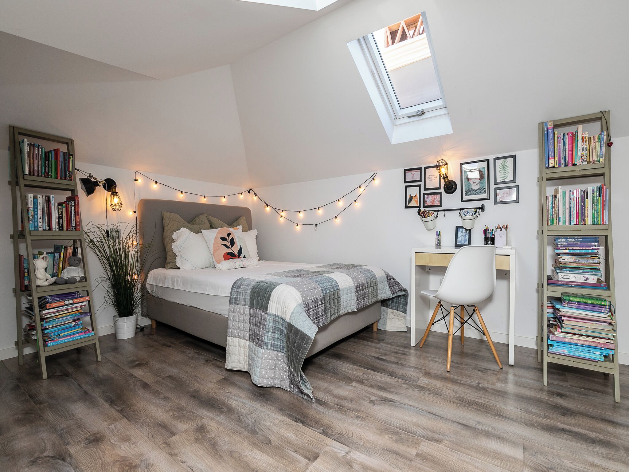 A bedroom with a loft bed, a desk, and bookshelves.