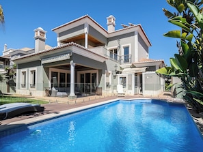 A two-story house with a swimming pool, large windows, and a balcony. - Walk in Hostel Faro (Faro)