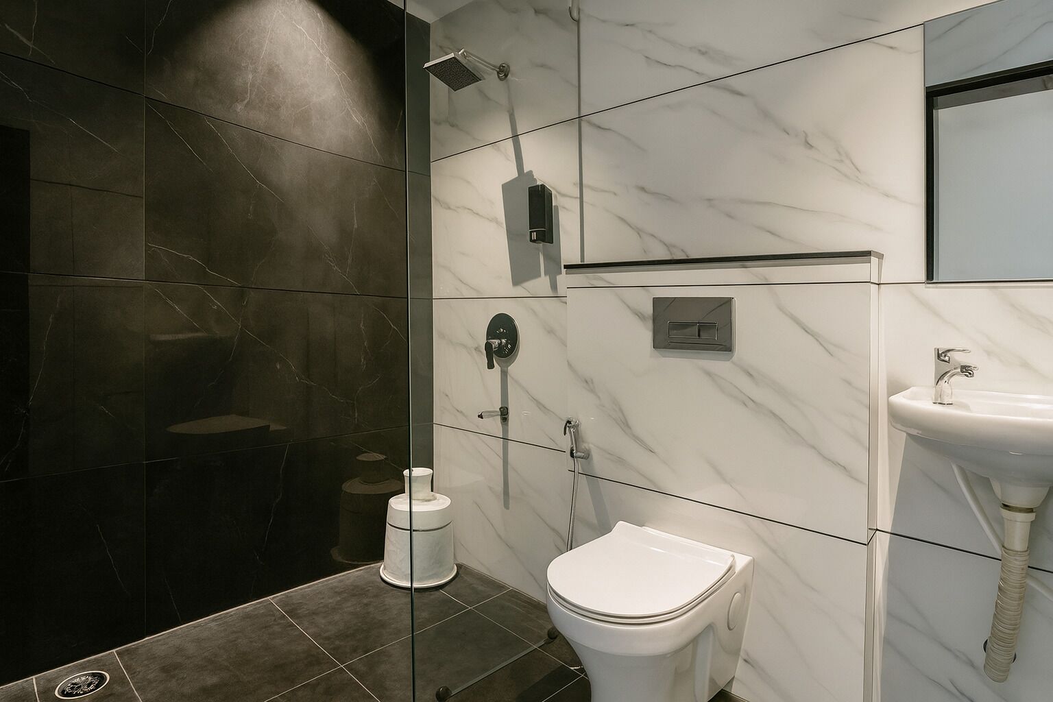 A modern bathroom with dark and light marble tiles, a glass shower enclosure, a toilet, and a sink.
