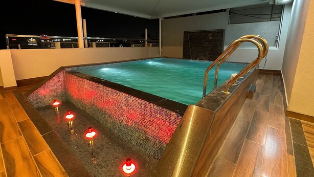 A rectangular indoor pool with a mosaic tile border and a built-in hot tub. - Hotel Benchmark Prime (Indore)