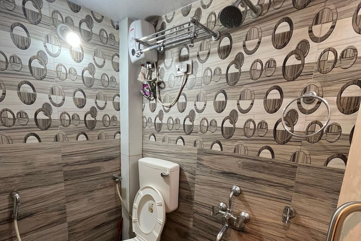A bathroom with a toilet, bidet, and shower. The walls have a circular pattern.