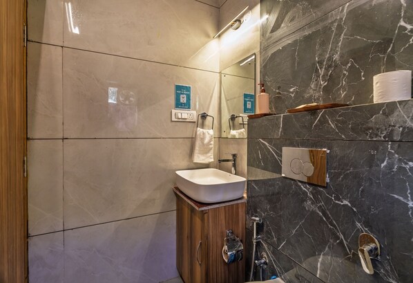 A modern bathroom with a white sink, wooden cabinet, and a marble shower wall. - LiveAway Mukteshwar by PACK (Kosiyakutoli)