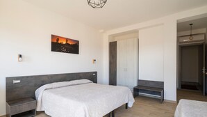 Ein Schlafzimmer mit Bett, Nachttischen, einem Kleiderschrank und einem Bild an der Wand.