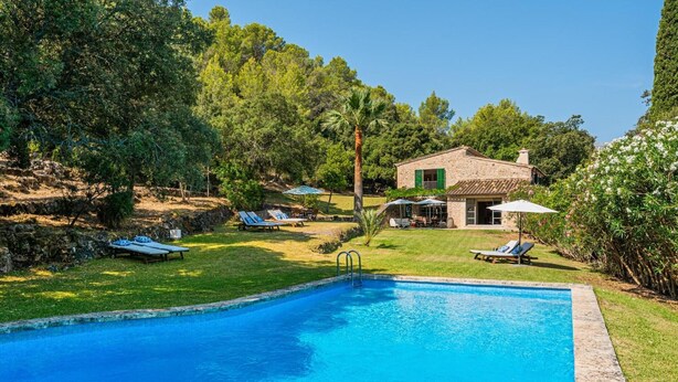 A swimming pool with lounge chairs and a stone building in a landscaped garden. - Villa 'Can Perot' with Mountain View, Private Pool and Wi-Fi (Pollença)