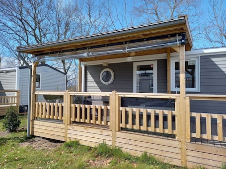 A wooden deck with a covered porch and a small window.