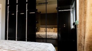 Ein Schlafzimmer mit Bett, Kleiderschrank und einem Fenster mit Vorhängen.