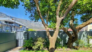 Une cour bordée d’arbres, avec un bâtiment en arrière-plan.