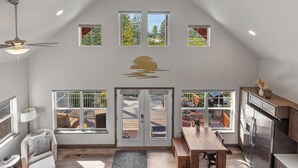 Ett rymligt kök i loftstil med matplats, stora fönster och utsikt över omgivningen.