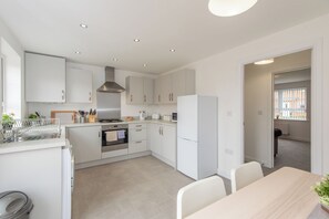 Eine moderne Küche mit weißen Schränken, einem Einbauofen und einem Kühlschrank.