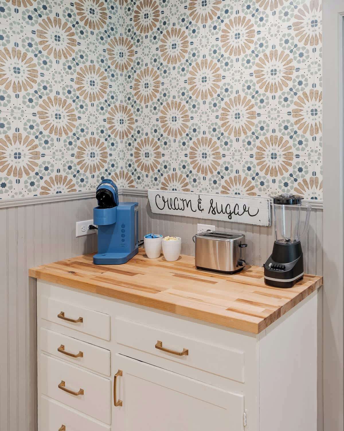 A kitchen with a wooden countertop, a coffee maker, a toaster, and a blender.