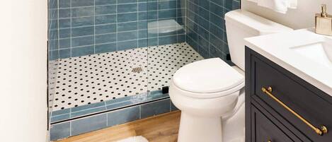 Ein Badezimmer mit Dusche, Toilette und Waschtisch.